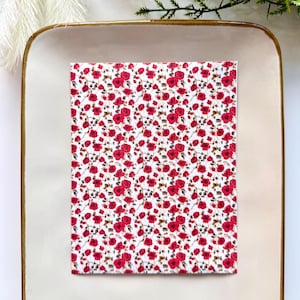 Puede incluir: Un trozo de tela rectangular con un patrón repetido de rosas rojas sobre un fondo blanco. Las rosas están en plena floración y tienen detalles. Ideal para proyectos de costura y manualidades.