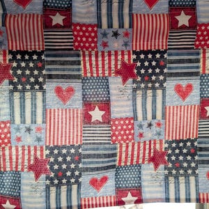 May include: A patriotic fabric with a patchwork design featuring red, white, and blue squares. The squares display stars, stripes, and hearts, creating a festive and Americana theme. The fabric is suitable for various crafting projects.