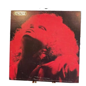 May include: A square vinyl record jacket featuring a high-contrast red and black portrait of a person with curly hair looking upward. The top left corner contains a gold rectangular stamp with the text DEMONSTRATION Not For Sale.