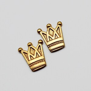 May include: Two gold-coloured crown-shaped metal charms.