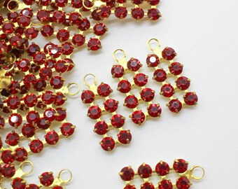 May include: A pile of red rhinestone chain trims with gold metal loops. The chains are made of small, round rhinestones.
