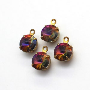 May include: Four iridescent rainbow-colored glass round charms with gold metal settings and loops. The charms are approximately 1 inch in diameter.