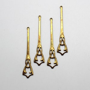 Puede incluir: Cinco piezas decorativas de metal dorado con un diseño intrincado. Las piezas son largas y estrechas, con un extremo puntiagudo y una parte superior decorativa.