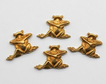 May include: Four gold-colored frog figurines, each with its arms crossed over its chest, are arranged in a circle on a white background.
