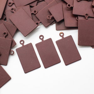 May include: Four brown rectangular cutting boards with a small metal loop at the top. The boards are arranged in a row on a white surface.
