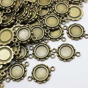 May include: A pile of antique gold-toned metal round pendant trays with scalloped edges and three jump rings.