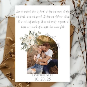 May include: A white Save the Date card with a photo of a couple, floral accents, and the text "Love is patient...Love never fails." The card includes the names "Hannah" and "Liam" and the date "10. 20. 25."