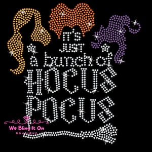 Pode incluir: Design gráfico preto com a frase "It's just a bunch of Hocus Pocus" em strass brancos. O design inclui silhuetas de cabelo em strass laranja, amarelo e roxo e uma vassoura em strass.