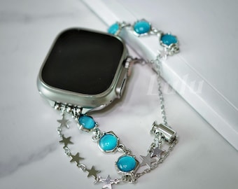 May include: A silver watch band with a blue gemstone design. The band has a chain with star charms and a blue gemstone on each link. The band is attached to a silver watch.