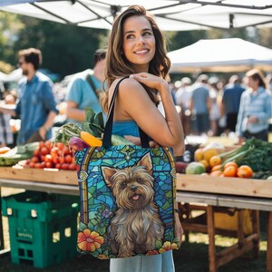 a woman holding a bag with a picture of a yorkshire terrier yorkie dog on it