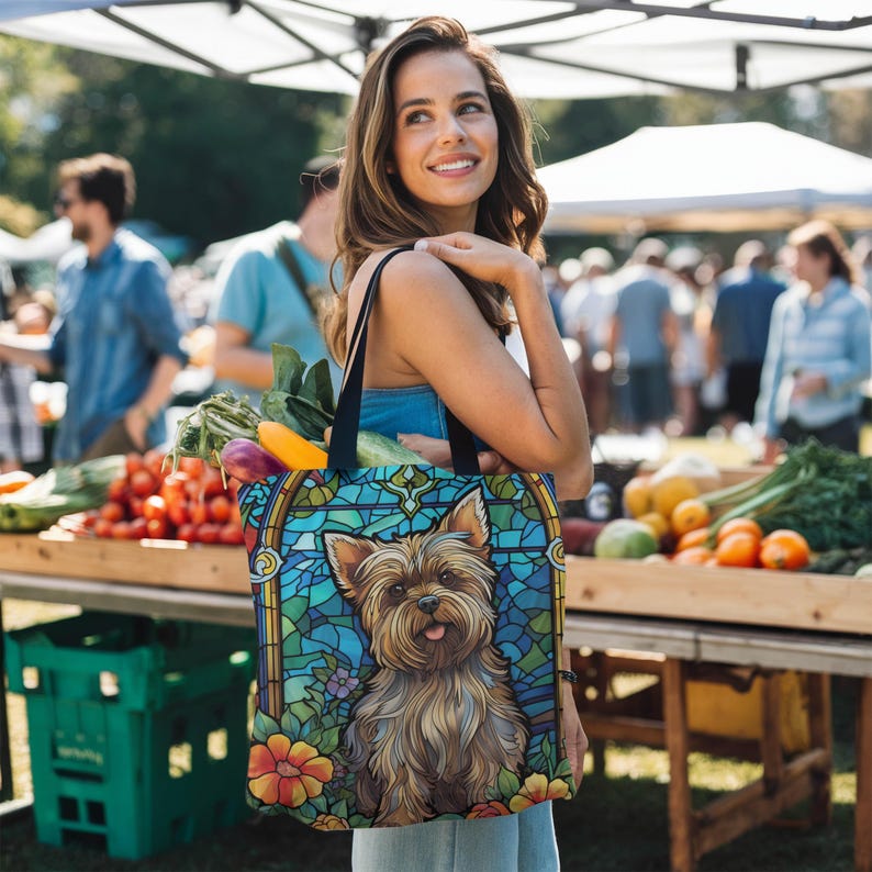 a woman holding a bag with a picture of a yorkshire terrier yorkie dog on it