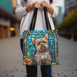 a woman is holding a bag with a picture of a yorkshire terrier yorkie dog on it