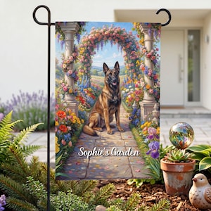 May include: A garden flag with a Belgian Malinois dog on a stone path, framed by a floral arch. The flag displays the text "Sophie's Garden". The dog is brown and black, with its tongue out, surrounded by colorful flowers.