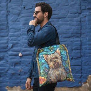 a man with a handbag that has a picture of a yorkshire terrier yorkie dog on it