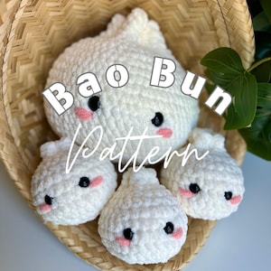 May include: A collection of white crocheted bao buns with black eyes and pink cheeks, arranged in a woven basket. The text "Bao Bun Pattern" is overlaid on the image.