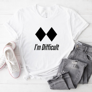 May include: White t-shirt with a black diamond symbol and the text "I'm Difficult".