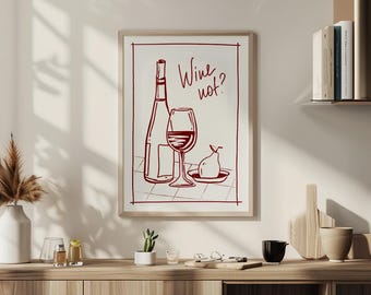 以下が含まれることがあります： ワインボトル、ワイングラス、お皿の上の梨の赤い線画が描かれた額入りのプリント。 「Wine not?」の文字がワイングラスの上にあります。 プリントは明るい色の壁に表示されています。