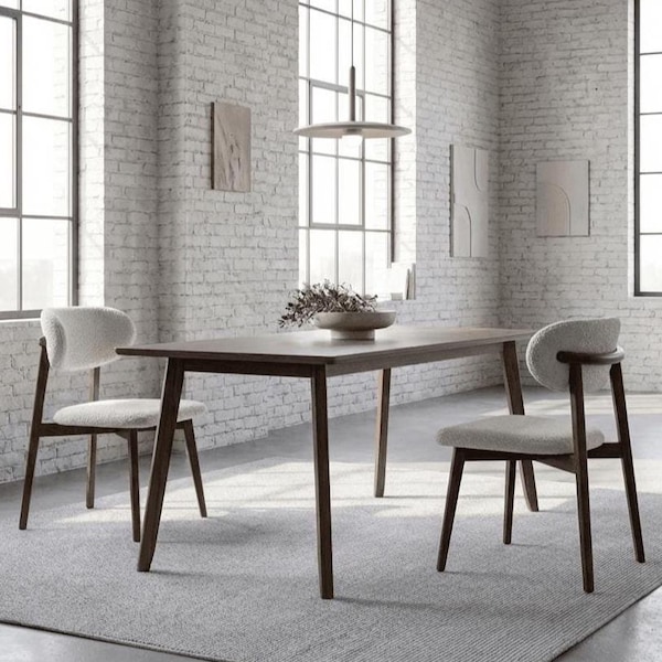 May include: A dining table and two chairs in a room with large windows. The table is dark wood, and the chairs have light-coloured, textured seats and backs. The room has a neutral colour scheme.