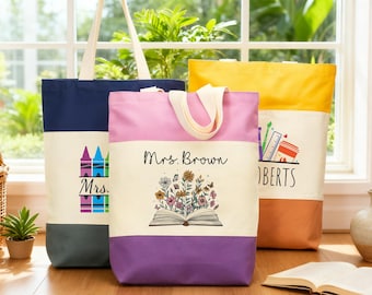 May include: Three canvas tote bags with cream-coloured handles and bases in navy, purple, and orange. The navy bag has a crayon graphic and the text "Mrs.". The purple bag has the text "Mrs. Brown" and a floral book graphic. The orange bag has the text "Roberts" and a school supplies graphic.