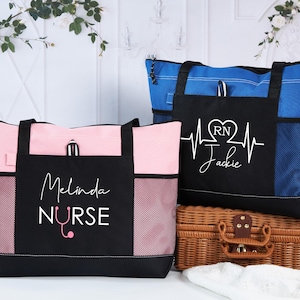 May include: Two tote bags, one pink and one blue, with black accents. The pink bag has "Melinda Nurse" printed on it, and the blue bag has a heartbeat design with "RN Jackie". Both bags have side pockets.