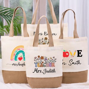 May include: A collection of canvas tote bags with various designs and text. One bag features a rainbow and the text "mrs. hugh", another says "Mrs. Brown", and a third says "LOVE mrs. Smith". The fourth bag says "TEACHER Mrs. Judith".