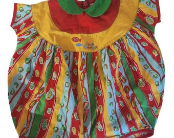 May include: A colorful baby romper with a striped pattern of red, yellow, green, and blue. The romper features a red top with a yellow collar and a green trim. The text "Jean Bourget" is embroidered on the front.