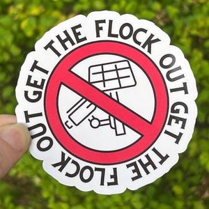 May include: A circular white sticker with a red prohibition symbol featuring a black line drawing of a flamingo. The text "GET THE FLOCK OUT" is printed in black capital letters along the top and bottom edges of the sticker's white border.