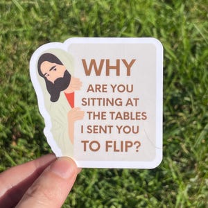 Peut inclure: Un autocollant avec une illustration de dessin animé d'une figure avec une barbe et une robe, regardant de côté. L'autocollant porte le texte "WHY ARE YOU SITTING AT THE TABLES I SENT YOU TO FLIP?"