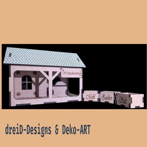 Könnte beinhalten: Eine Miniatur-Bäckerei aus Holz mit gemustertem Dach, einem Fenster und drei beschrifteten Kisten. Die Bäckerei trägt den Text "Wichtelwerkstatt" auf einem Schild. Der Text "dreiD-Designs & Deko-ART" befindet sich unten.