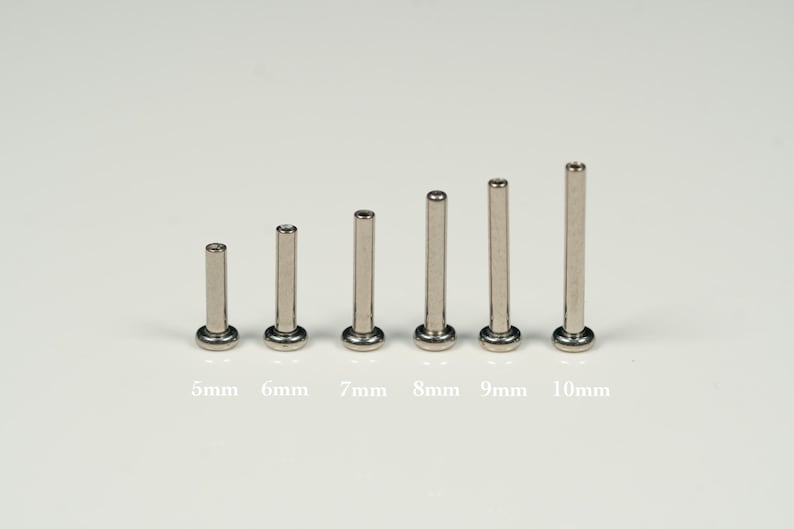 Pu&ograve; includere: Un set di sette aste metalliche argentate di diverse lunghezze, che vanno da 5 mm a 10 mm. Le aste sono disposte in ordine di dimensione, con l'asta pi&ugrave; piccola a sinistra e l'asta pi&ugrave; grande a destra.