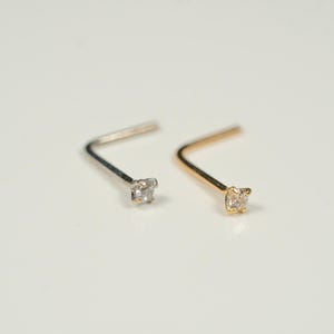 Puede incluir: Dos anillos de nariz con una peque&ntilde;a piedra preciosa transparente. Un anillo es de plata y el otro es de oro.