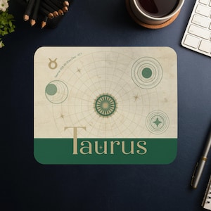 Könnte beinhalten: Rechteckiges Mauspad mit dem Sternzeichen Stier im Vintage-Karten-Design. Das Mauspad hat einen cremefarbenen Hintergrund mit grünen und goldenen Akzenten, einschließlich des Stiersymbols und dem Wort "Taurus".