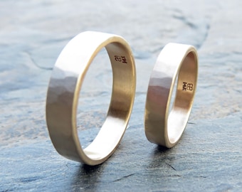 May include: Two gold wedding bands with a hammered finish. The bands are marked with "14K" and "18K".
