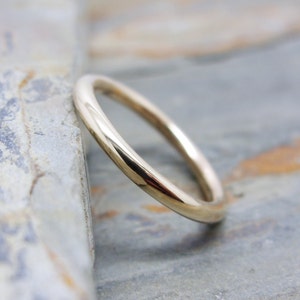 May include: A simple gold wedding band with a smooth, polished finish.