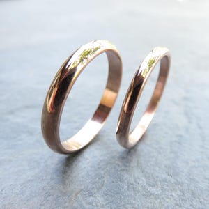 Shiny 14k rose gold wedding rings. Classic traditional polished domed wedding band set. 3mm and 2mm D-shaped half round court profile rings.