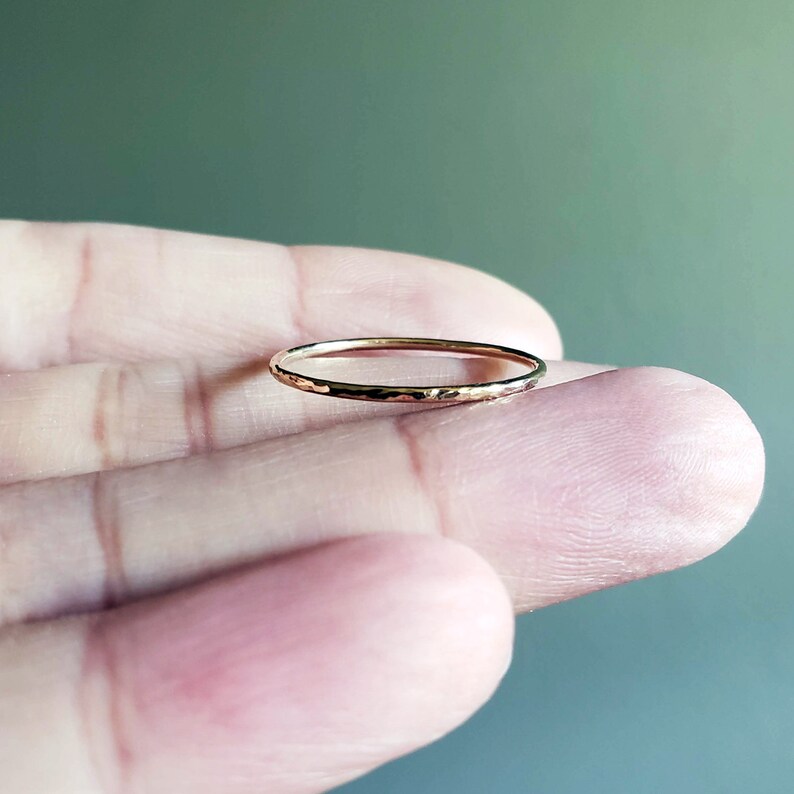 Pu&ograve; includere: Un sottile anello a fascia d'oro con una texture martellata.