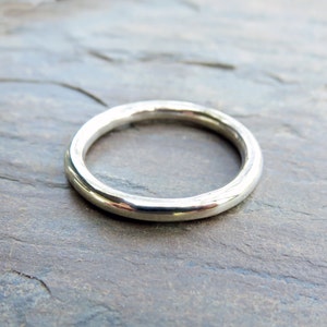 Può includere: Un anello semplice in argento con una superficie liscia e arrotondata.