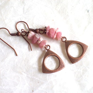 May include: A pair of copper earrings with pink stone beads and a triangular pendant with a circle cutout.
