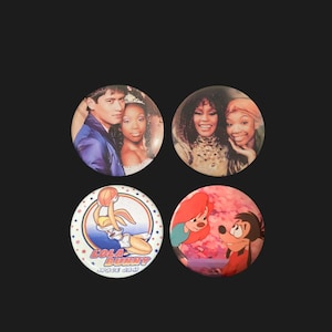 May include: Four round buttons with different images. The first button features a photo of two people, a man and a woman, smiling. The second button features a photo of two women, smiling. The third button features a cartoon image of a rabbit playing basketball with the text "Lola Bunny Space Jam". The fourth button features a cartoon image of two characters, a red-haired woman and a dog.