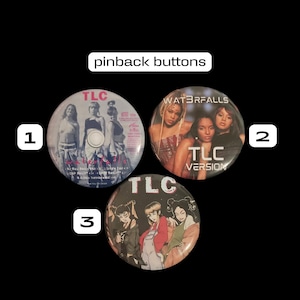 May include: Three pinback buttons featuring images of the R&B group TLC. The first button features a photo of the group from their album "FanMail" with the text "TLC" in pink. The second button features a photo of the group from their album "Waterfalls" with the text "TLC Version" in pink. The third button features an anime-style illustration of the group with the text "TLC" in pink.
