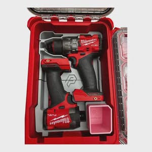 Peut inclure: Un ensemble de perceuse et visseuse à percussion Milwaukee FUEL rouge et noir dans une mallette rigide rouge. La mallette est ouverte, révélant les outils dans un insert gris. Un conteneur rose est également visible.