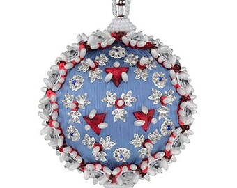 May include: A blue, spherical Christmas ornament with detailed beadwork and decorative elements. It has red, white, and silver accents, a beaded hanging loop, and a teardrop-shaped bead. The design incorporates floral and geometric patterns.