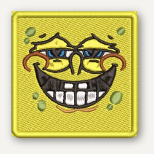 May include: A square yellow embroidered patch featuring a stylized cartoon face with heavy eyelids, a wide black grin showing white teeth, and scattered green spots. The design is outlined with a thick yellow border and uses black thread for details.
