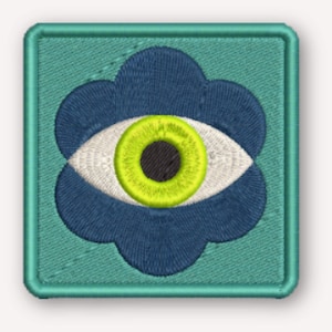 Puede incluir: Un parche bordado cuadrado con fondo verde azulado y un motivo en forma de flor azul oscuro. Centrado en la flor hay una forma de ojo blanco con un iris verde lima brillante y una pupila negra, todo acabado con un borde verde azulado a juego.