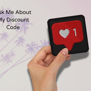 Flat lay of Micro Influencer patch iron-on with red Instagram heart icon, 1 Like text, on neutral background, showing crisp embroidery and playful self-deprecating humor, perfect for jackets, backpacks, or gifts.