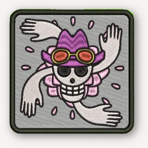 May include: A square embroidered patch featuring a white skull wearing a purple hat with orange-rimmed goggles and black sunglasses. The skull is surrounded by four white hands and small pink petal-like shapes on a light gray background.