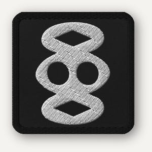 Puede incluir: Un parche cuadrado bordado en negro que presenta un símbolo blanco cosido en el centro. El diseño consta de dos formas de diamante apiladas conectadas a una sección central que contiene dos recortes circulares, delineados en hilo blanco.