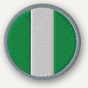 May include: A circular embroidered patch featuring a vertical triband design with two green outer sections and a central white stripe. The entire patch is bordered by a thick, light gray stitched edge, creating a clean and defined circular shape.