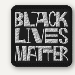 Puede incluir: Un parche bordado de forma cuadrada con fondo negro y el texto blanco "BLACK LIVES MATTER" cosido en una fuente negrita sin remates. El parche tiene un borde grueso cosido en negro y esquinas redondeadas, lo que le da un acabado limpio.