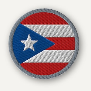 Puede incluir: Un parche bordado circular que presenta la bandera de Puerto Rico. El diseño consiste en un triángulo azul en el lado izquierdo con una estrella blanca de cinco puntas en el centro, y franjas horizontales rojas y blancas alternadas.